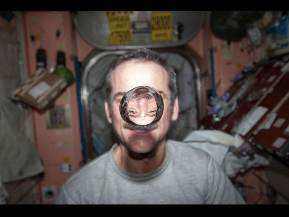 Chris Hadfield's inverted, smaller image must be BEYOND 2f in the convex "lens" that is a floating sphere of water in space. 