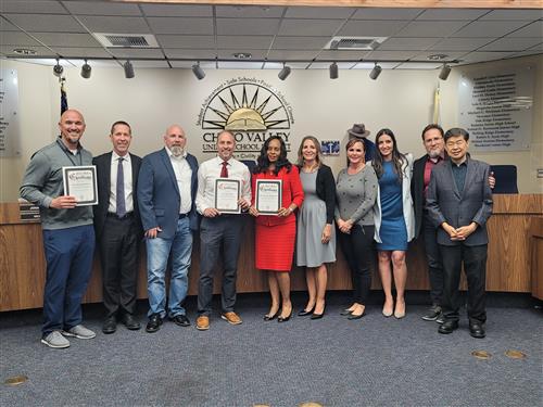 Principals Buoncristiani, Miller, and Yarboi pose with Dr. Enfield and the Board of Education holding certificates. 