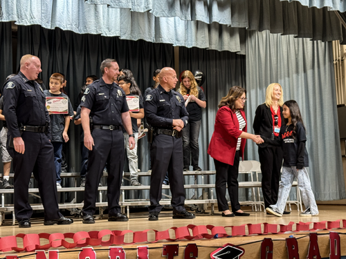 Student walking across stage during DARE graduation.