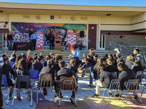 D.A.R.E. gradates sitting and listening to a Chino PD officer speak.
