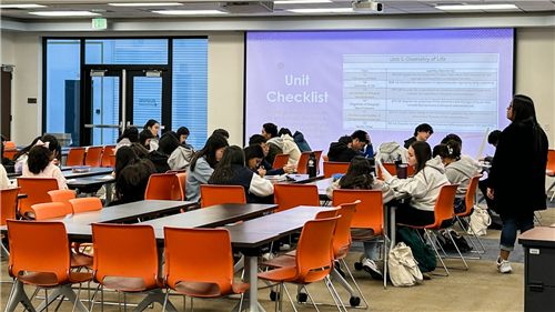 Students enrolled in AP Chemistry work while teacher projects material on the screen.