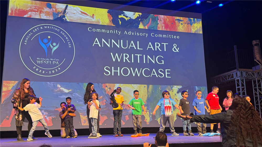  A group of students performing on stage at the Art & Writing Showcase