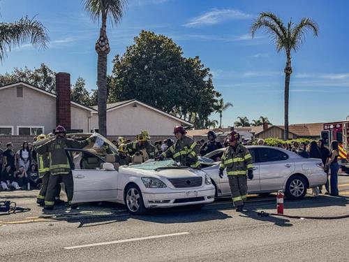 Firefighters attending to a staged traffic collision