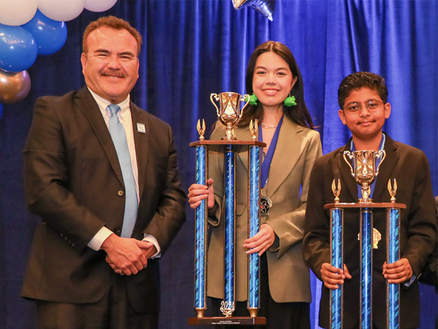 Two students holding trophies at the science fair
